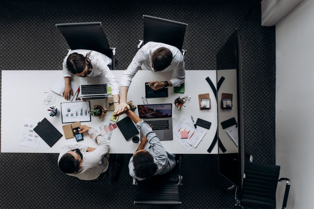 High angle view of colleagues collaborating around a conference table in a modern office setting.